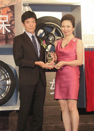 表彰盾を手にする上海優科豪馬輪胎販売有限公司の竹内保徳総経理（左）と汽車族誌の孫剛氏