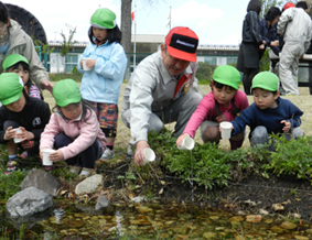 保育所の子どもたちと一緒に放流（写真中央：塚越工場長）