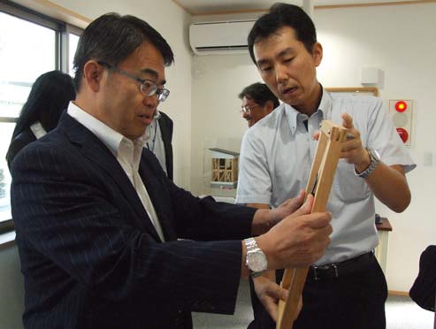 木造住宅用制震システム「TRC ダンパー」について説明を受ける大村知事（左）