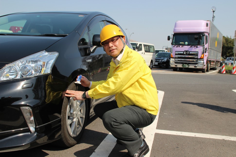 タイヤ点検をする津谷正明会長（ＪＡＴＭＡ）