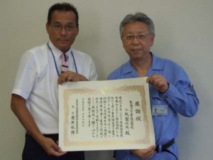 感謝状を手にする臼井社長（左）と田中睦・小牧製作所長