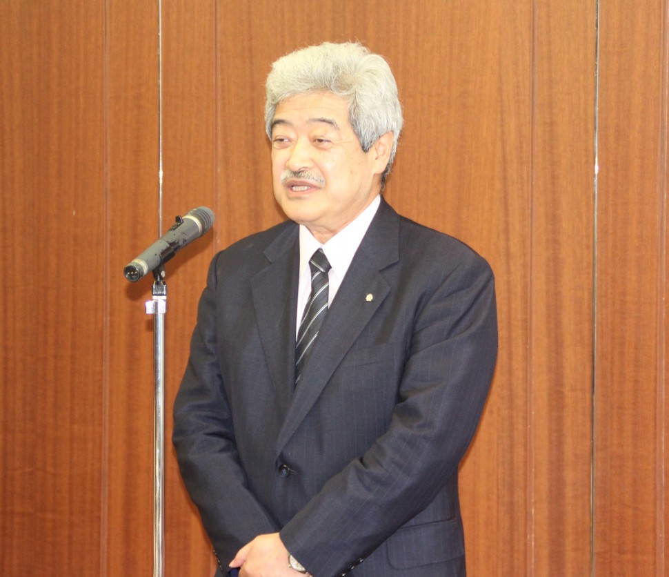 あいさつする岩﨑幸次郎新会長