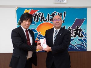 植樹会に先立ち平野公三大槌町長（右）にタイヤの目録を手渡す八柳史横浜ゴム環境保護推進室長