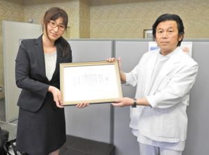 兵庫県立福祉のまちづくり研究所の陳隆明所長（右）から感謝状を受け取る