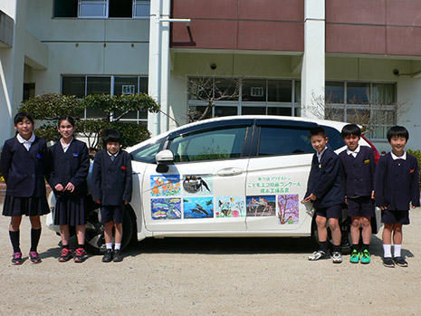 受賞作品をプリントした社有車（築山小学校）