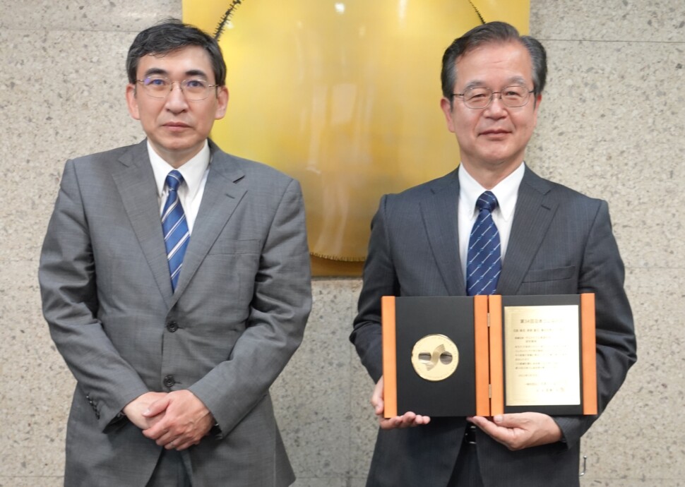日本ゴム協会会長（左）より表彰盾を授与された日座氏