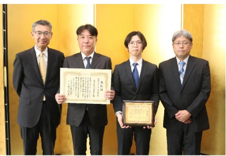 表彰式の様子（写真左から）代表取締役社長坪原健太氏、システムパートリーダー永塚大商氏、品質管理チームスタッフ菊地康平氏、常務取締役製造部長河本英男氏