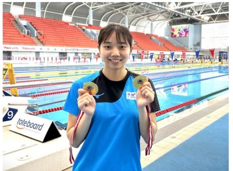 金メダルを手に笑顔を見せる飯塚選手
