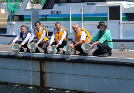 ヒラメの稚魚を放流する出席者