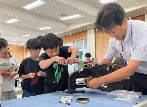 革端材でコインケースを作る児童